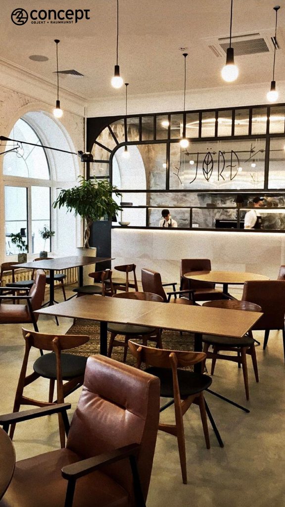 Elegante skandinavische Möbel und Lichtquelle im rauen industrial-Look des Restaurants